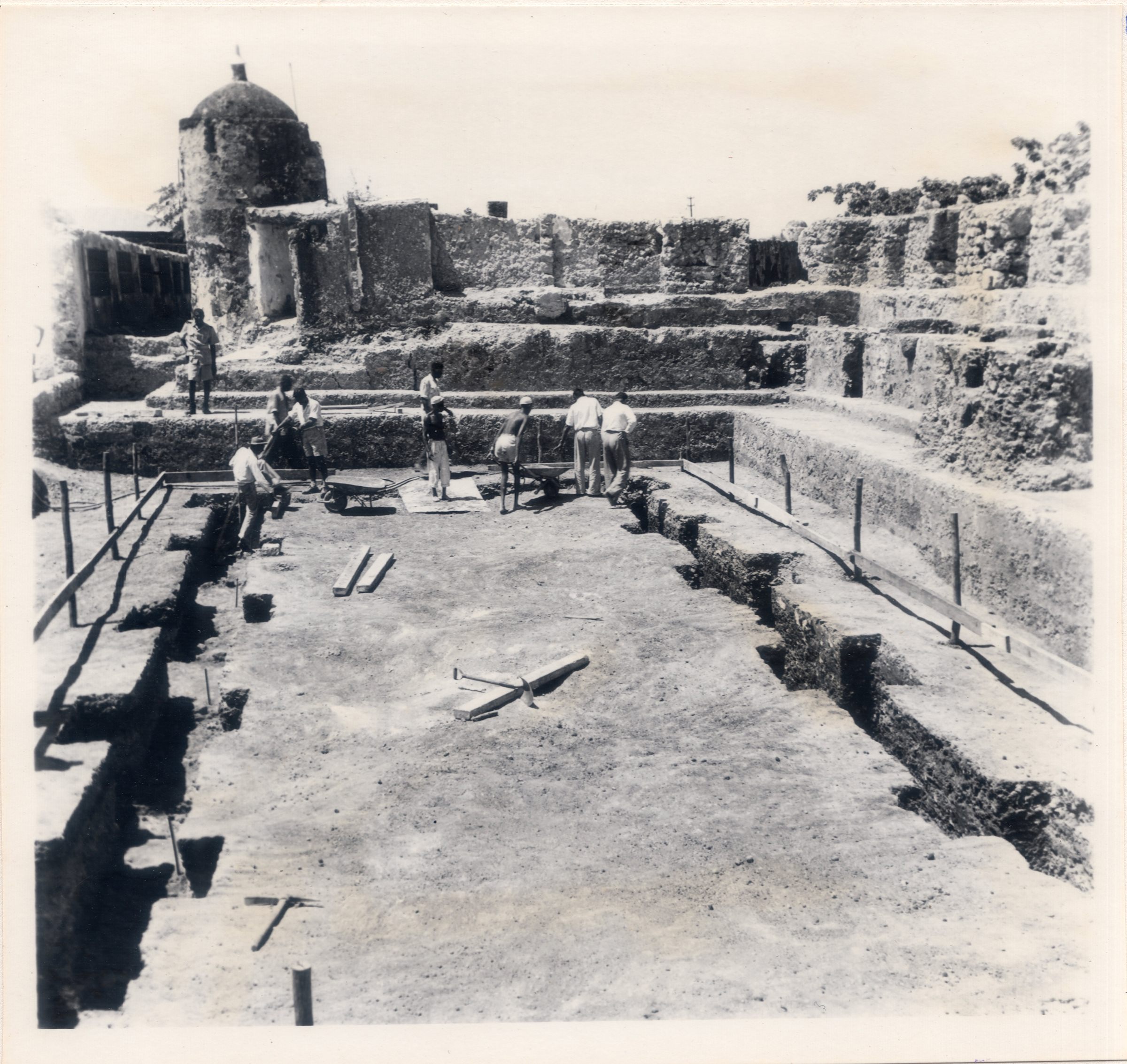 Ashikoye Okoko came across a box of roughly 500 images of excavations at Gedi and Fort Jesus in the 1940s and 1950s. Three of those, like this one, show Karisa Ndurya (top left) overseeing the excavations at Fort Jesus in 1959. The other individuals in this photo are unidentified.