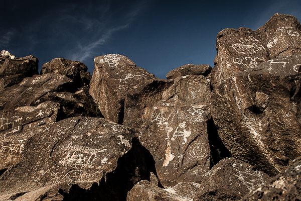 Large panel of diverse figures on several basalt boulders.