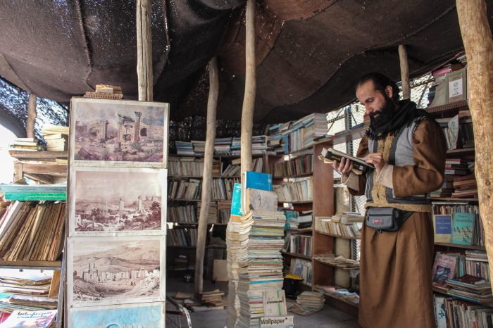 Hamzeh perusing volumes under the bookstore tent in Amman.