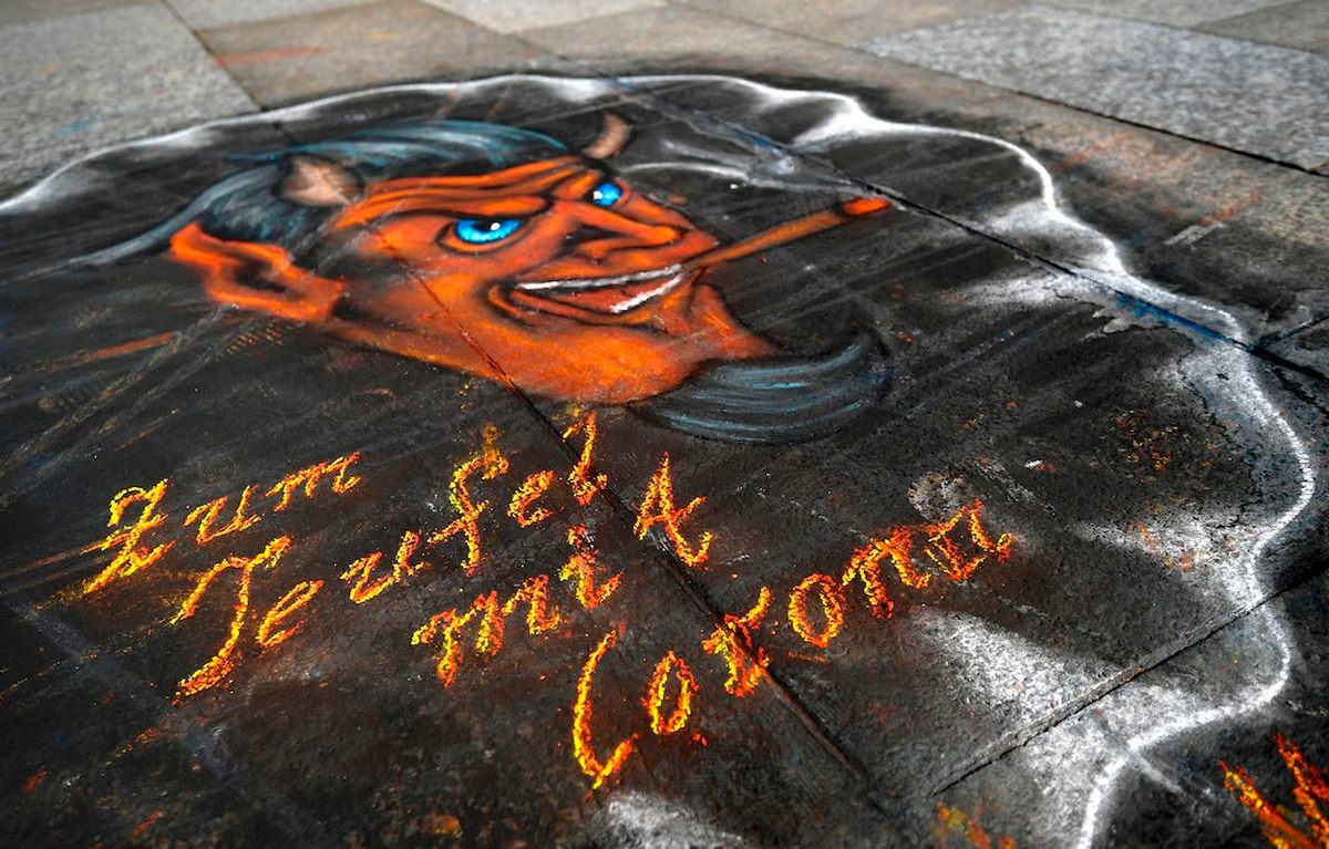 This graffiti in front of Cologne Cathedral in Germany says "To hell with Corona," March 17, 2020.