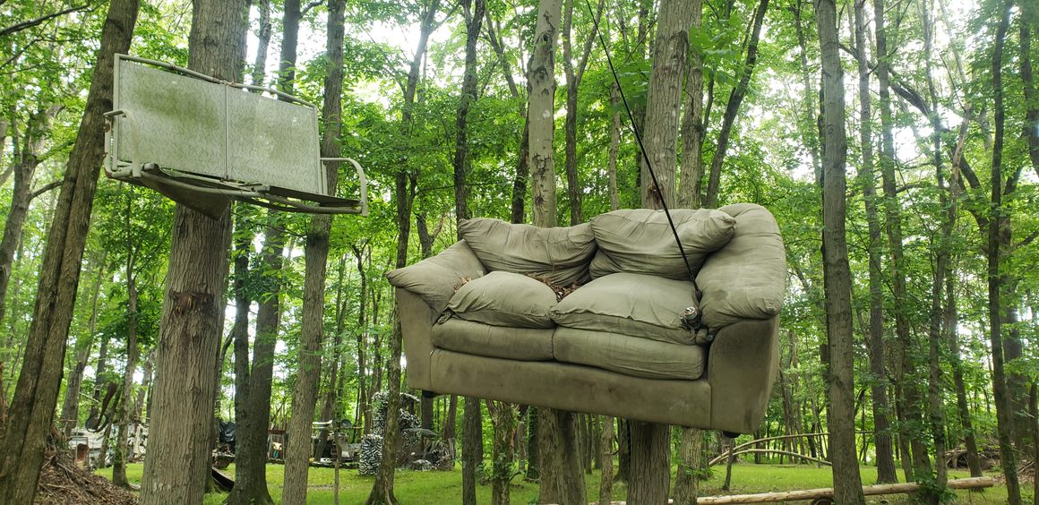 A couch on a tree with a fishing rod attached to it, otherwise known as Casting Couch.