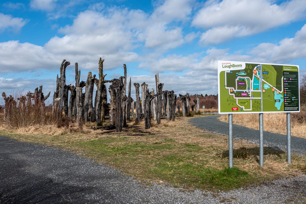 A trail map greets visitors as they walk toward a collection of ancient bog wood which was unearthed on this site as peat was mined.