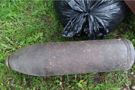 The 100-year-old artillery shell beside more conventional trash.