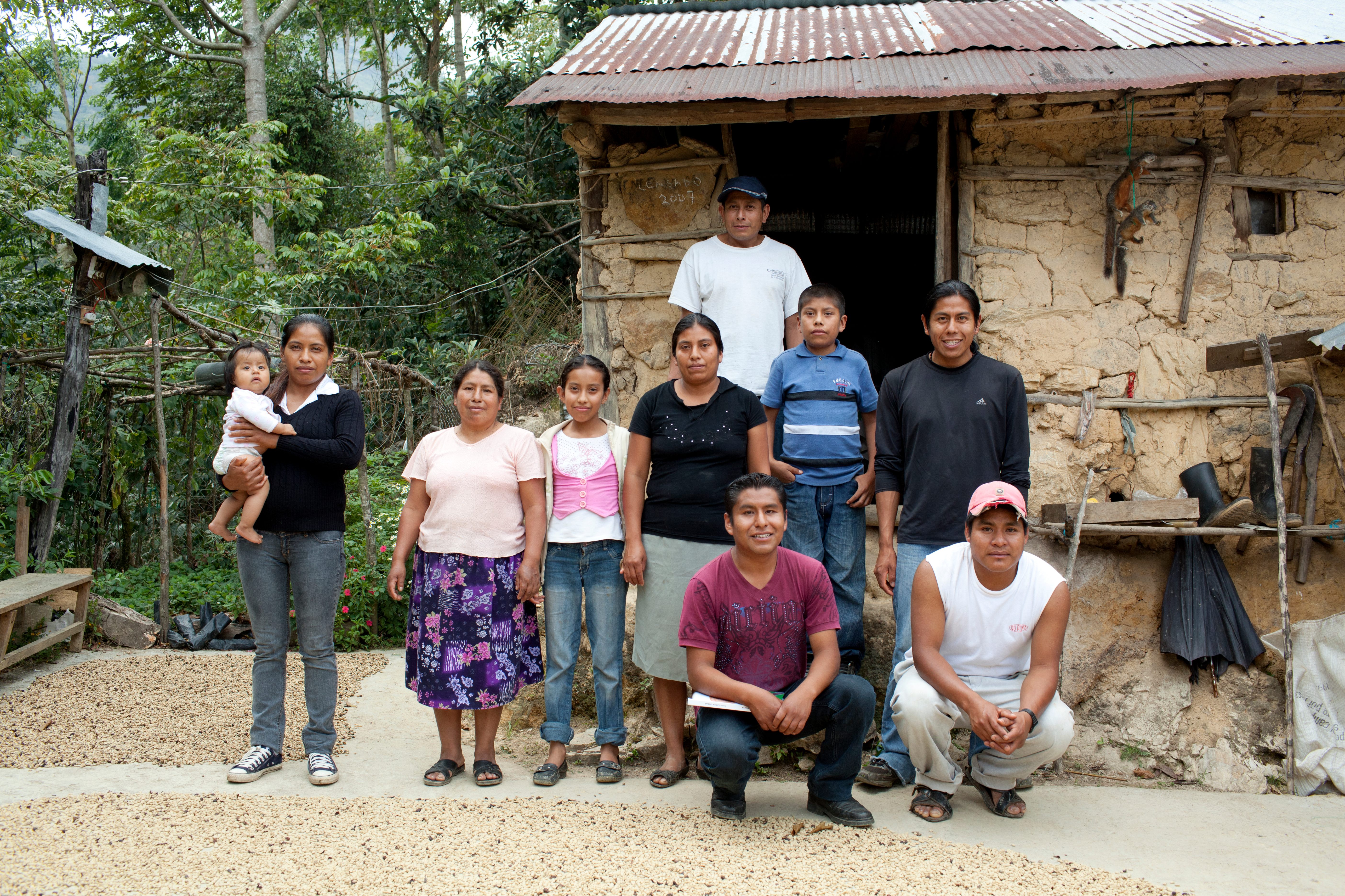 Julián Isidro (in red, front) with his family in front of their home.