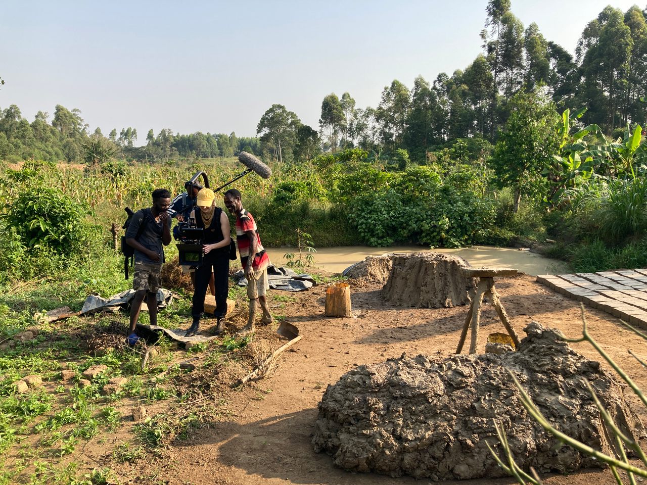 Kids gather around cinematographer Megan Eleanor Clark's camera for the filming of Atlas Obscura's film, <em>The Ugandan Quidditch Movement</em>.