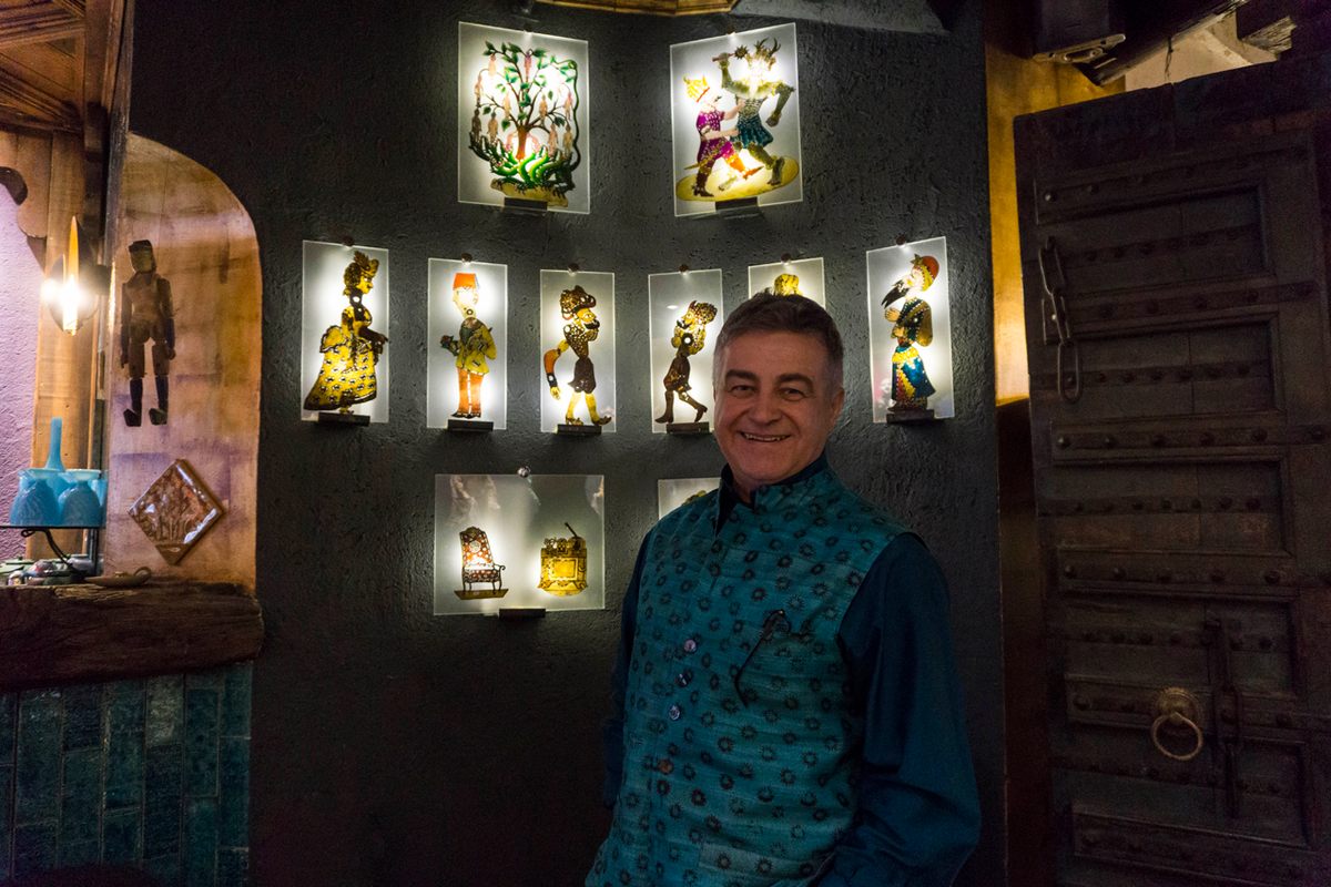 Inside his theater in Istanbul, Özek stands in front of a collection of Karagöz figures, a small sample of his creations over the years.