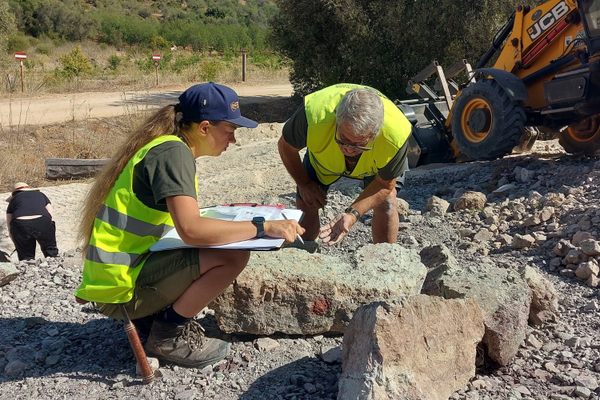Klara Gerken and Ignace Nerinckx look over a block beside the excavator.