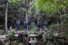Small statues of Buddha line the path to the top of the mountain.