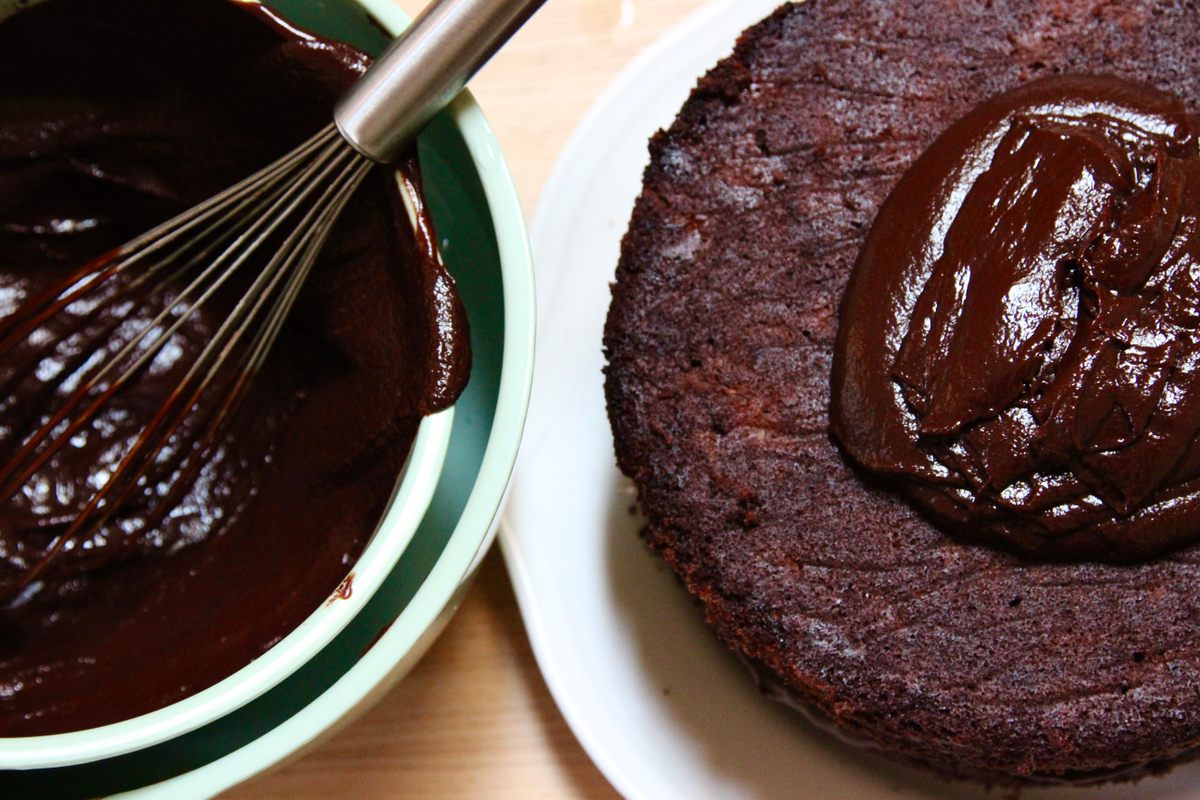 Spreading the ganache frosting.