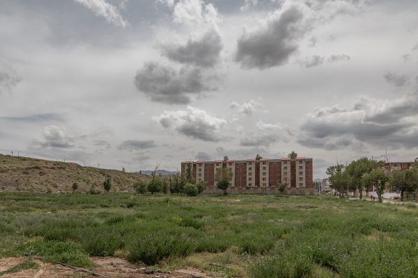 Open field in front of a condominium.