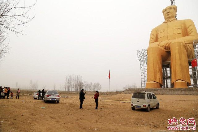 Visitors dwarfed by the huge Mao.