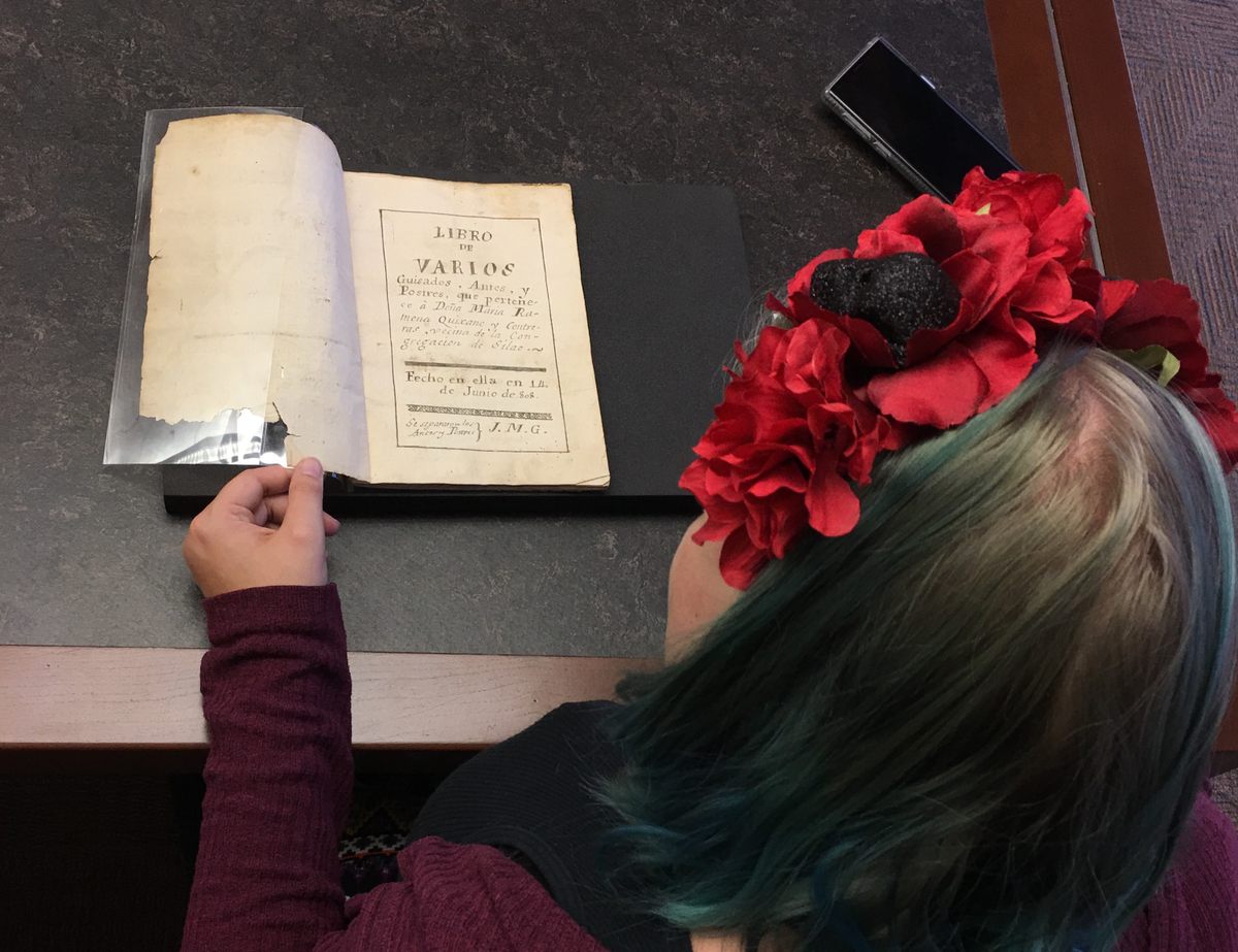 A student browses the collection's second-oldest cookbook. The digitized copy is slated to be uploaded today.