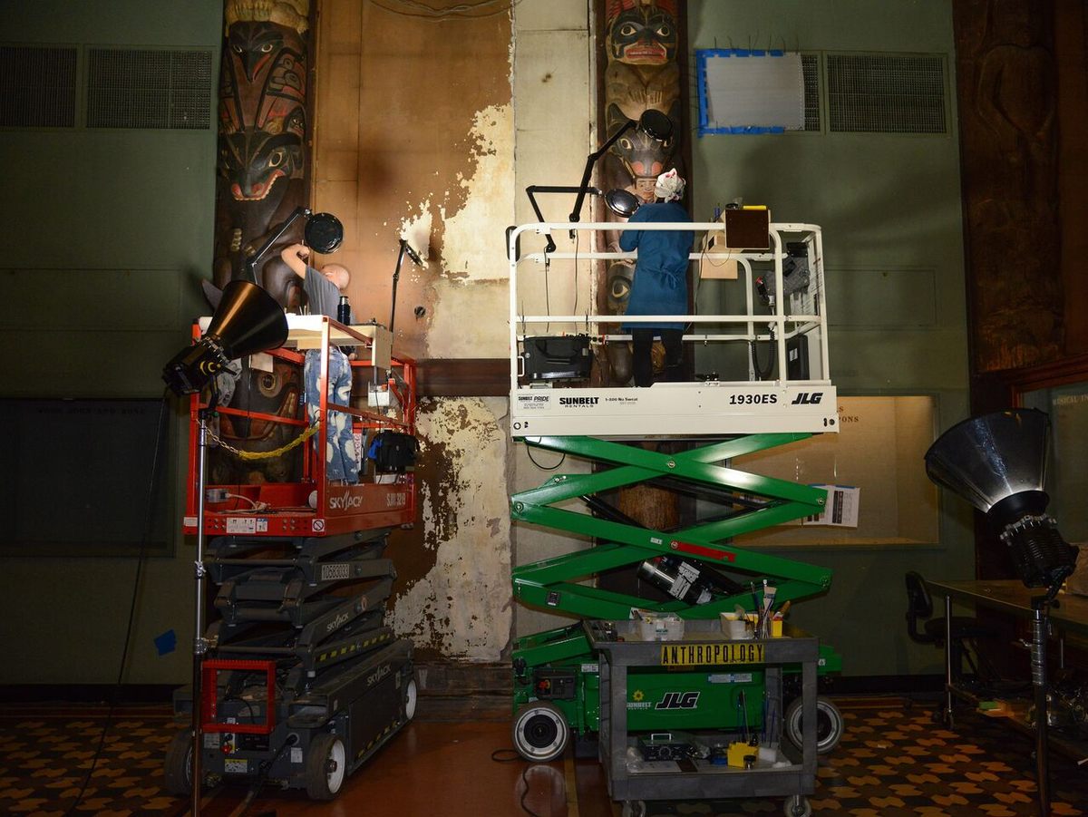 Assistant conservators William Sit (left) and Linda Lin (right) spend hours up on lifts to reach the figures high on the posts.