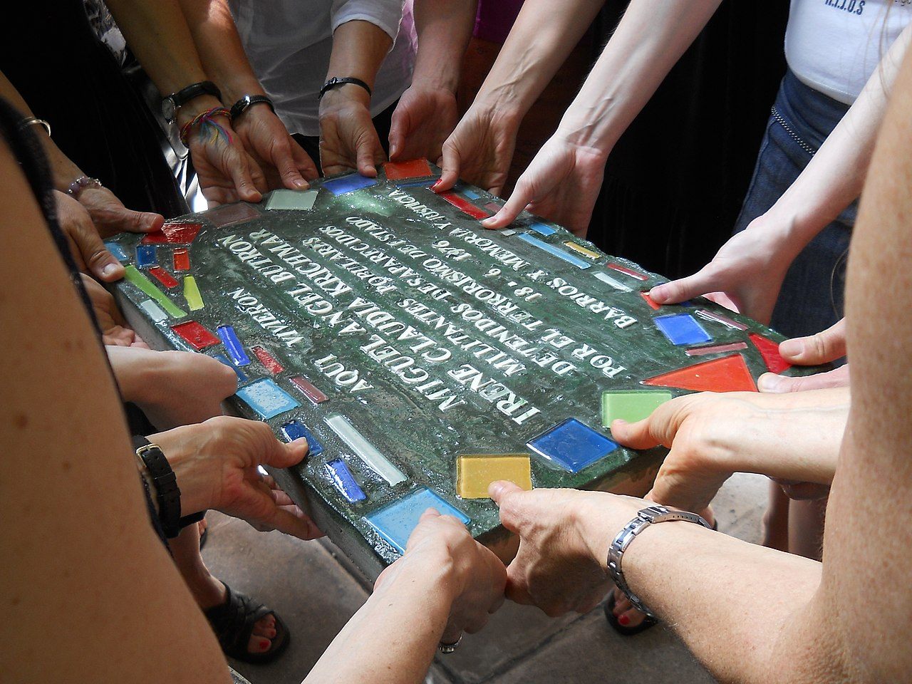 Laying a tile for Irene Claudia Krichmar and Miguel Ángel Butron.