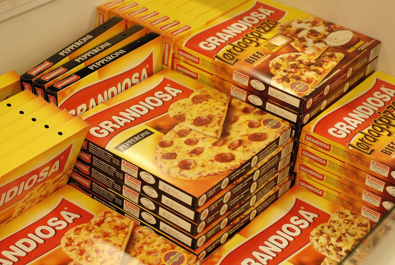 Stacks of Grandiosa pizza at the supermarket, ready to be heated up and eaten. 