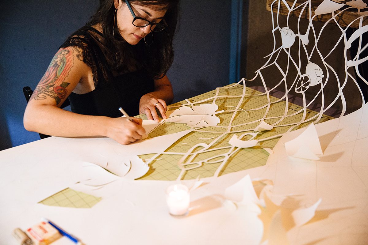 Local artist Lauren Iida creates verdant worlds that blossom from intricately cut reams of paper.