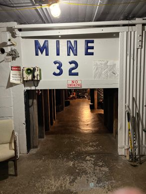 Small white tunnel entrance inside a building with the words "Mine 32" above in large, blue letters.