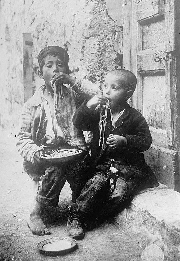 Two boys eating pasta, Naples, c. 1900.