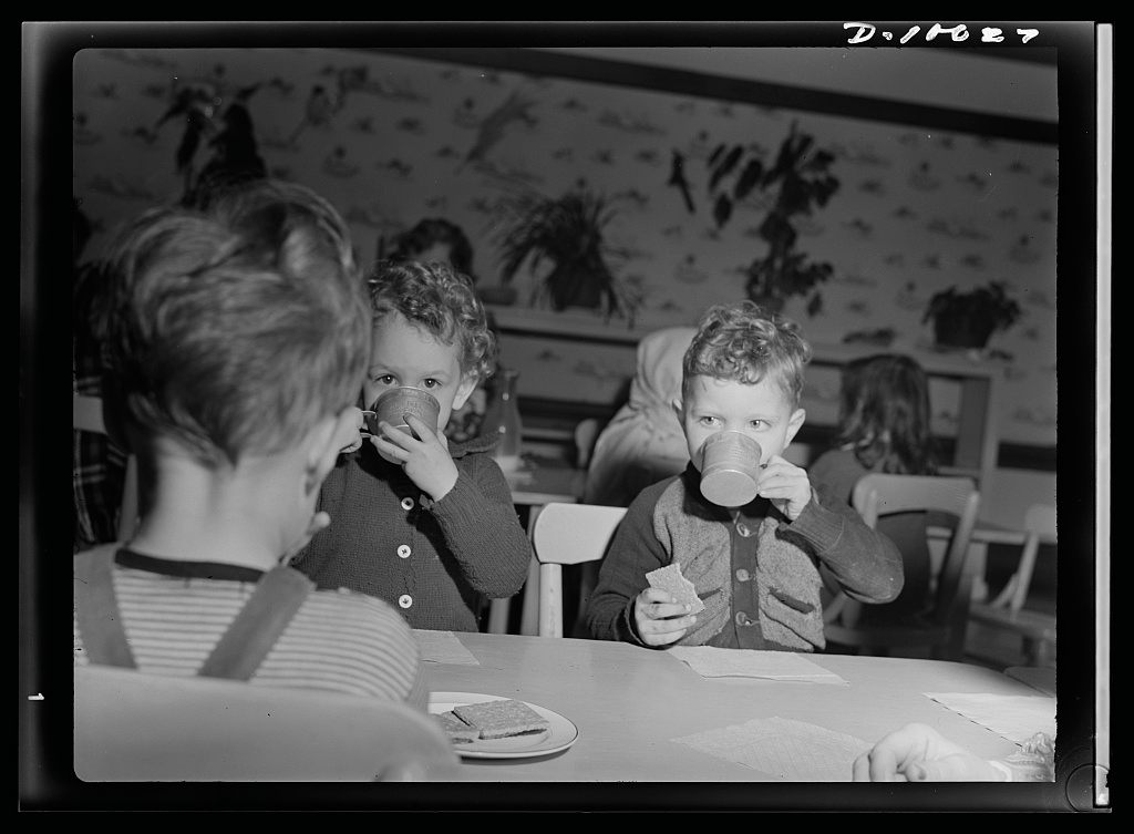 Children snack on milk and graham crackers, 1943.