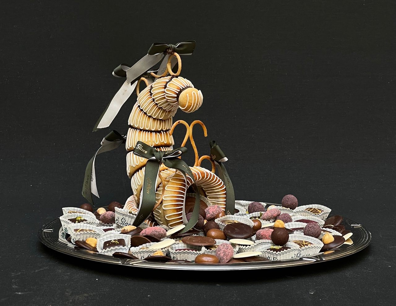 From the cavity of this florid horn emerges dozens of petit fours and chocolates in a bountiful display of plenty.