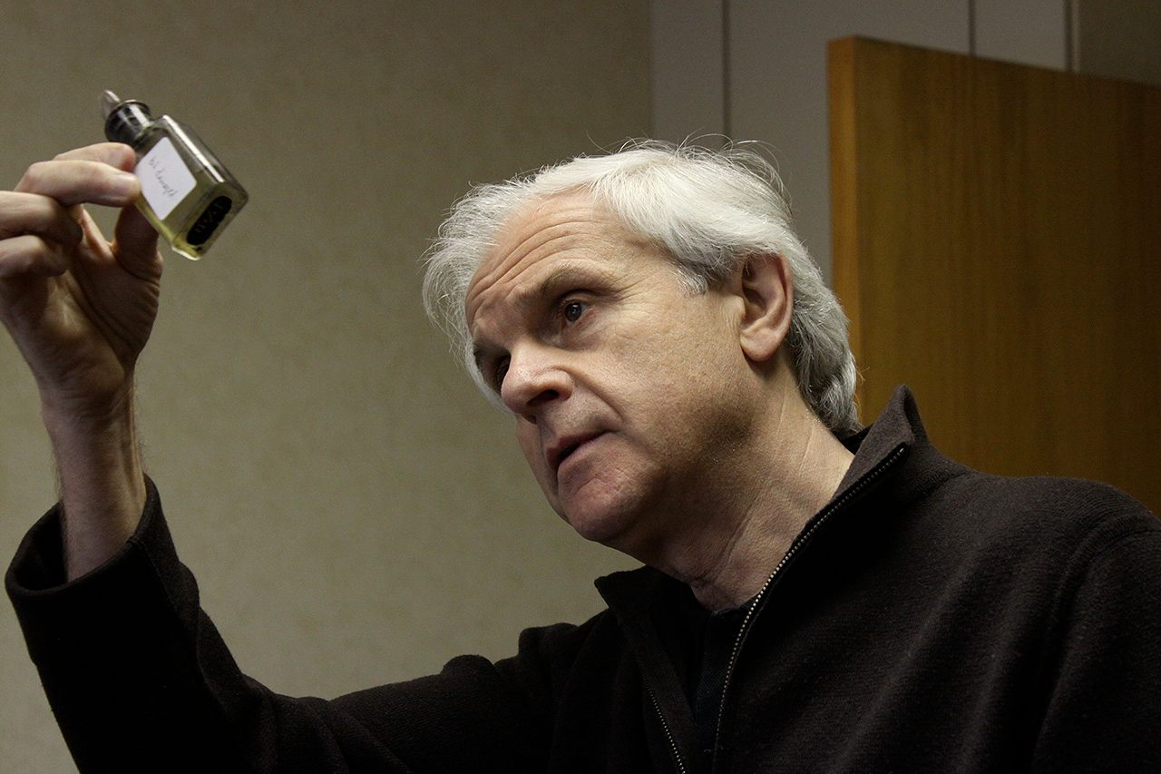Jean-Claude Delville looks carefully at the liquid inside the bottle.