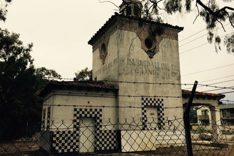 It sits behind chain link and barbed wire