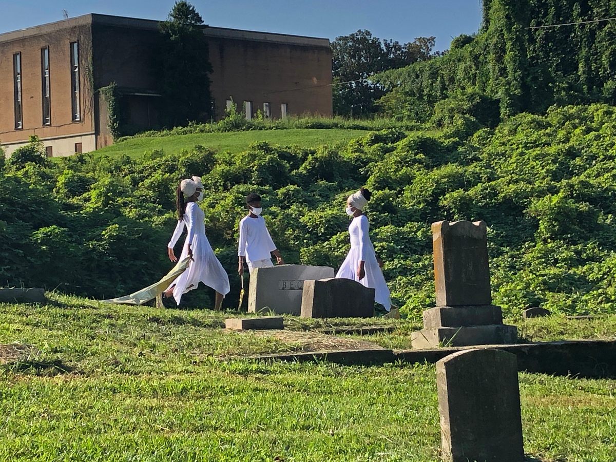 Dancers Felecia, Ray, and Liz (right to left) approach the headstone of James Garfield Beck and Ethel J. Benson Beck, long-time civic leaders in Knoxville's Black community.