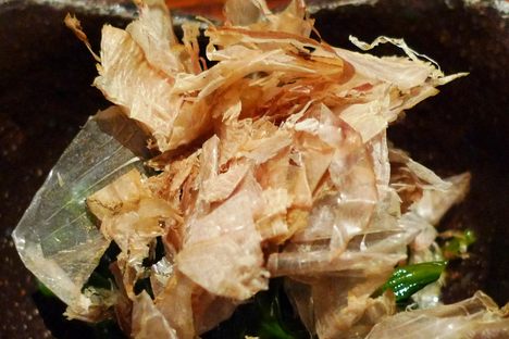 Spinach leaves topped with bonito flakes.