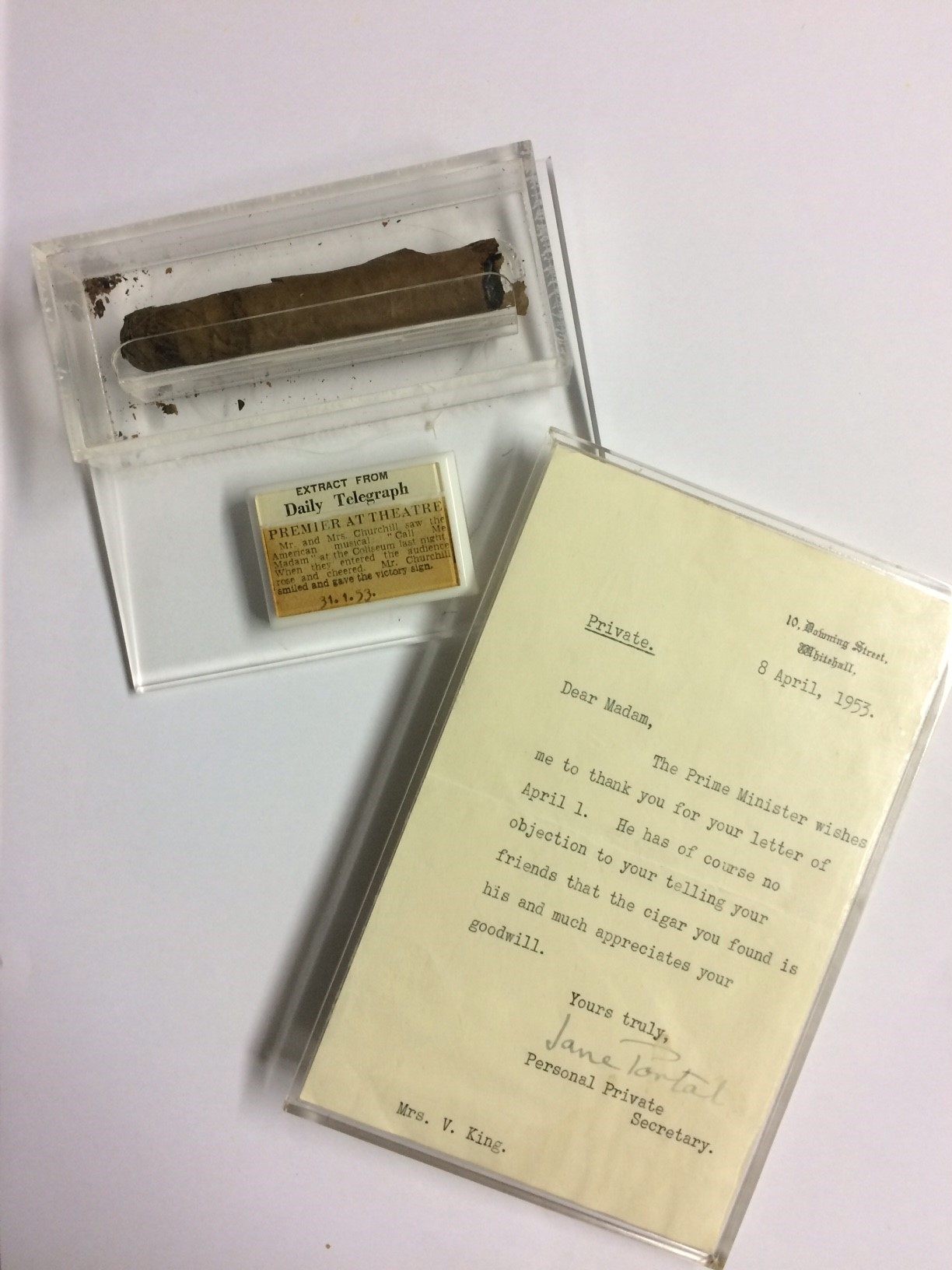 The cigar is paired with an old newspaper clipping and a letter from 10 Downing Street.