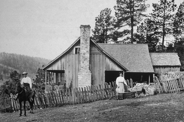 A family poses outside their homestead, somewhere out west, in the late 19th century. 