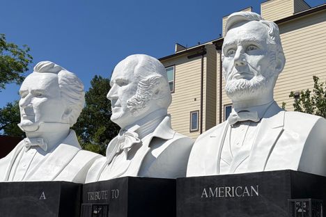 The busts sit on marble pedestals, visible from the Katy Freeway.