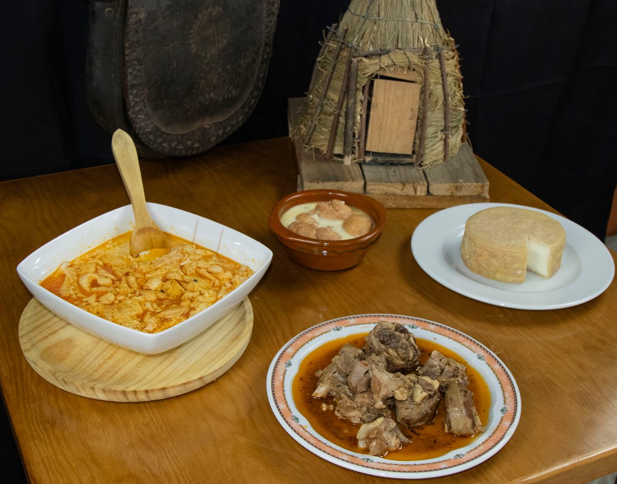 Traditional shepherds’ fare (starting left, clockwise) of sopas canas (“white-haired soup”), sapillos, goat cheese, and Extremeño stew, all made with goat milk or meat.