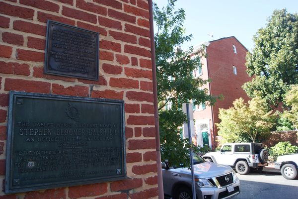 The plaque in foreview, with JFK’s green doorstep across the street.