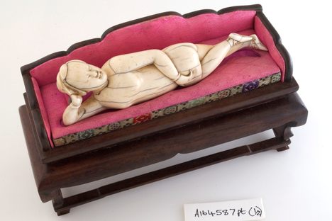 A diagnostic doll reclines on a miniature couch.