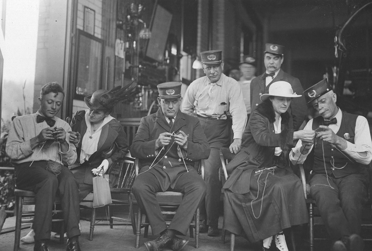Firemen with the Cincinnati Fire Department being taught to knit by members of the American Red Cross, 1918.