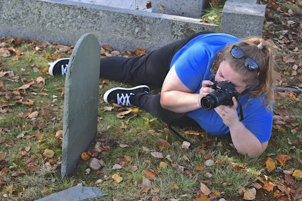 Anthropologist Kerri Klein photographs a gravestone at Burial Hill.