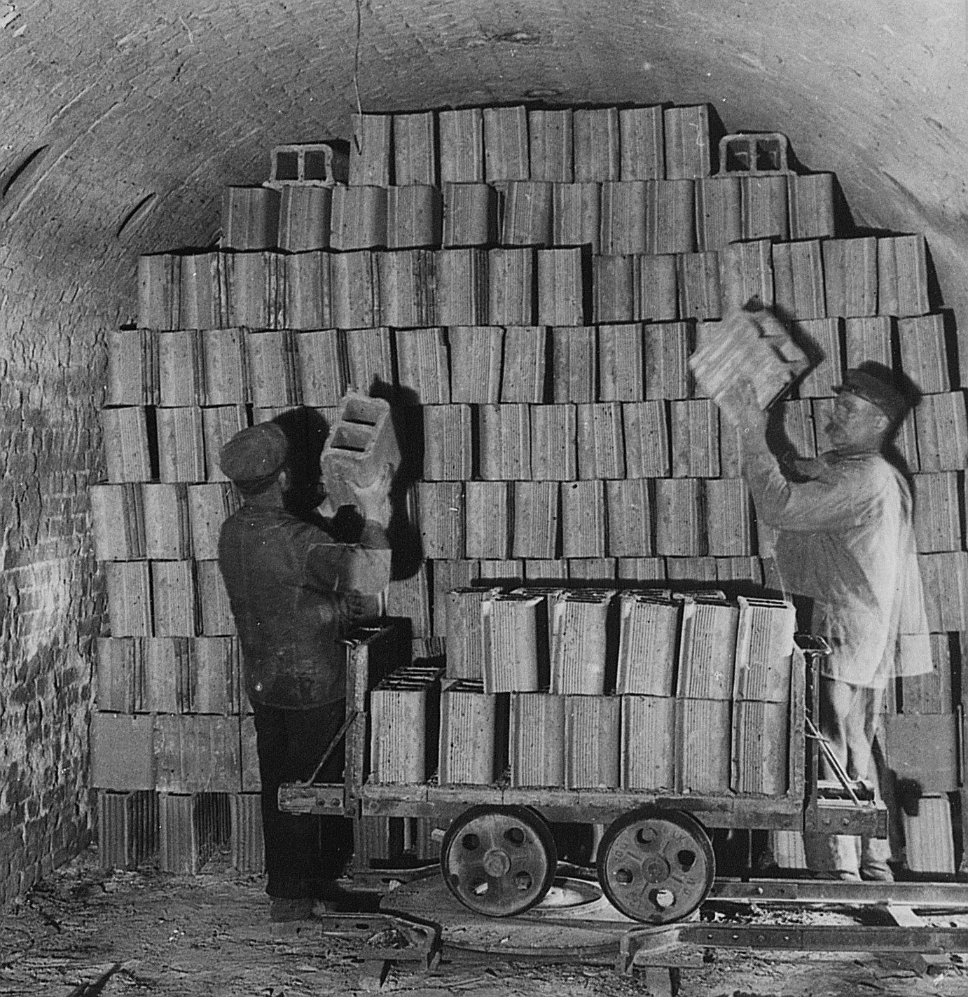 Inserting raw bricks in a ring furnace in the early 20th century.
