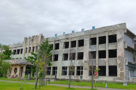 The front of the school, showing both the ruined building and interpretive centre additions. The structure on the right provides a lookout over empty fields that were once bustling residential streets.