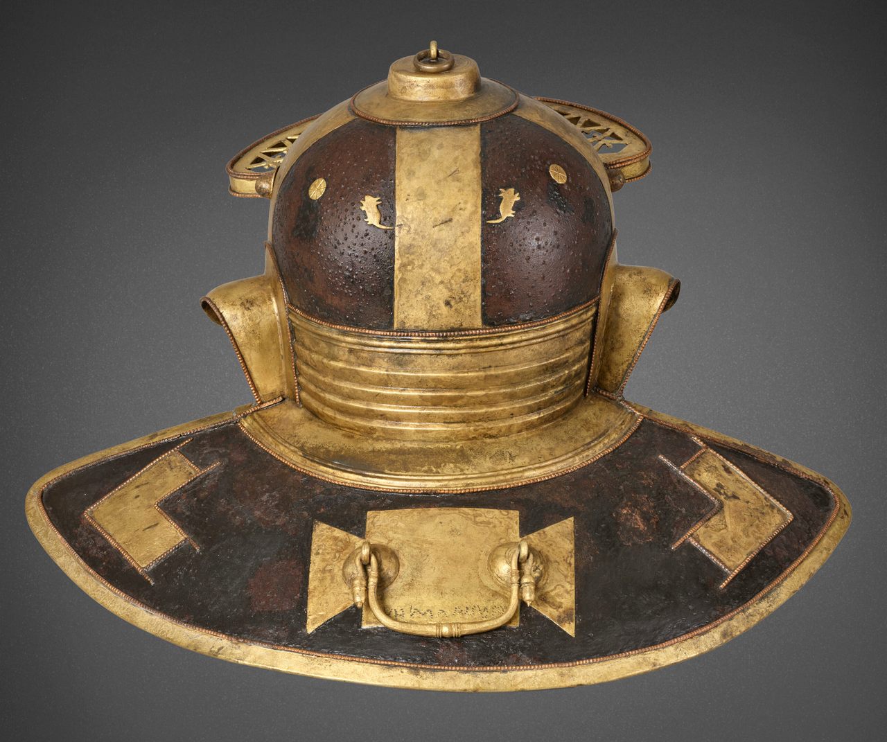 The ornate Guttmann Mouse Helmet, seen from the rear, includes depictions of what scholars believe are two mice and loaves of bread. 