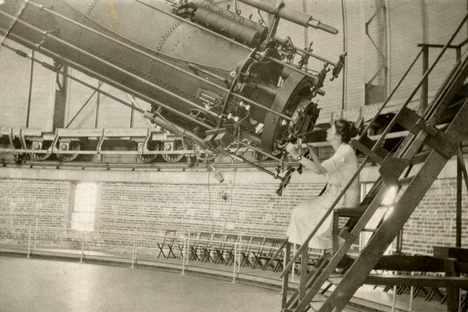 A female astronomer peers through Yerkes Observatory's massive refractor telescope in Williams Bay, Wisconsin.
