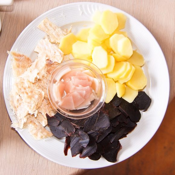 Clockwise from top right: potatoes, whale meat, and dried fish, with blubber in the center.