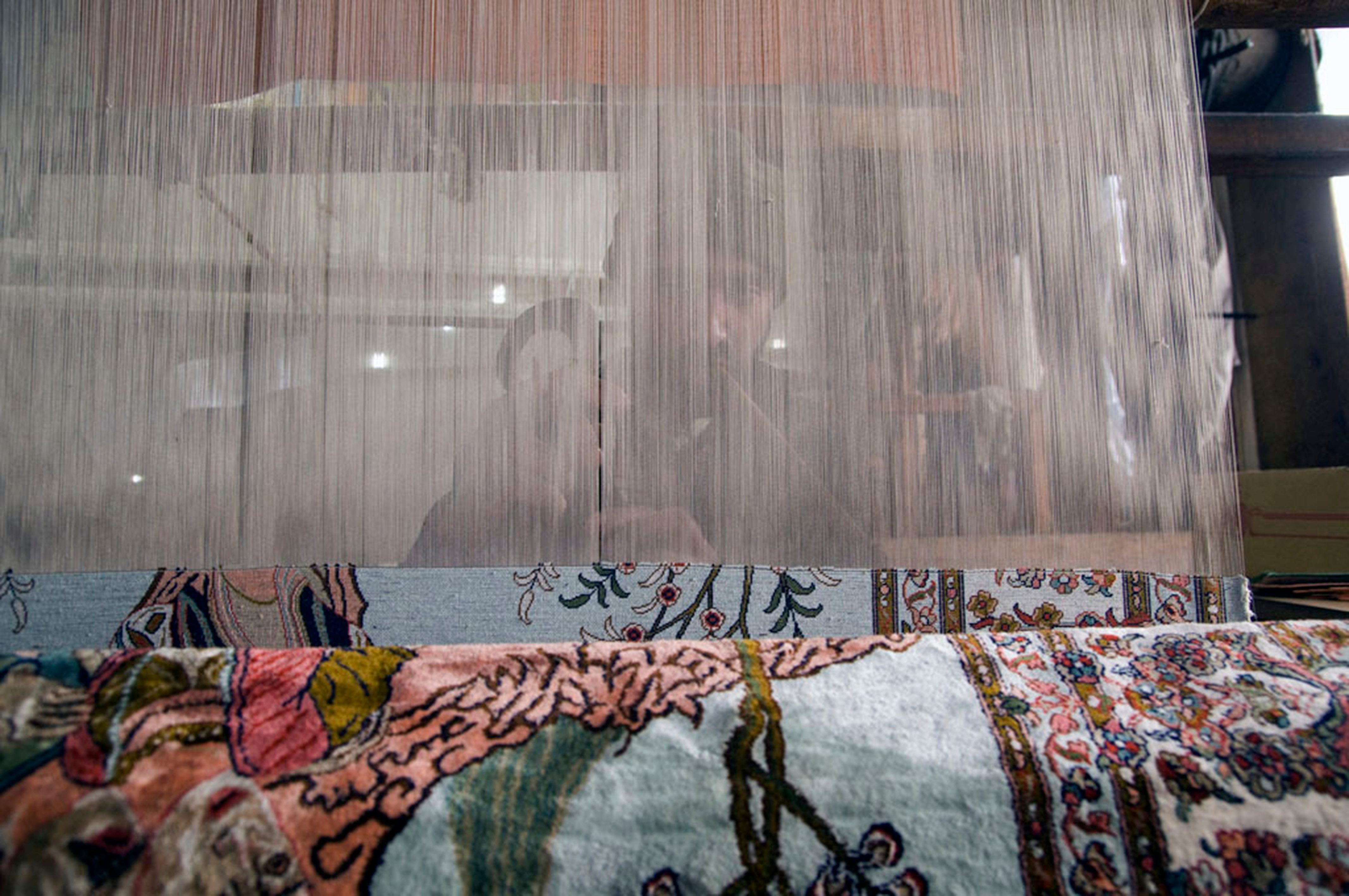 Faiyyaz, a carpet weaver, is busy behind his wooden loom, a family possession for three generations.