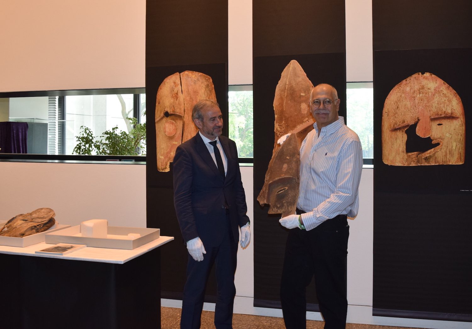 Hermann Parzinger, president of the Prussian Cultural Heritage Foundation, presents a Chugach artifact to John Johnson (right).