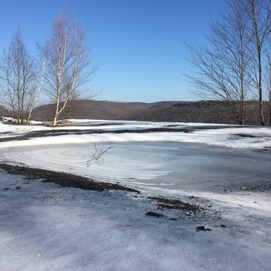 An icy pond forms just behind the brink of the viewpoint.
