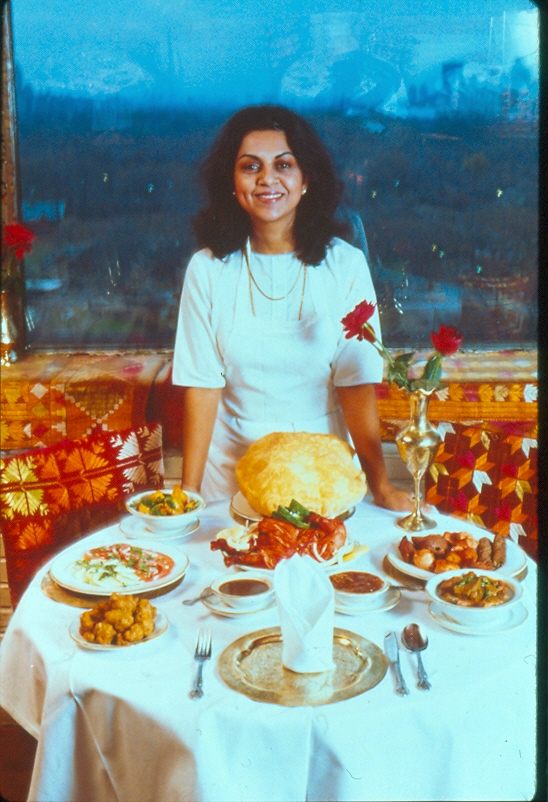 Julie Sahni before a spread of regional Indian dishes.