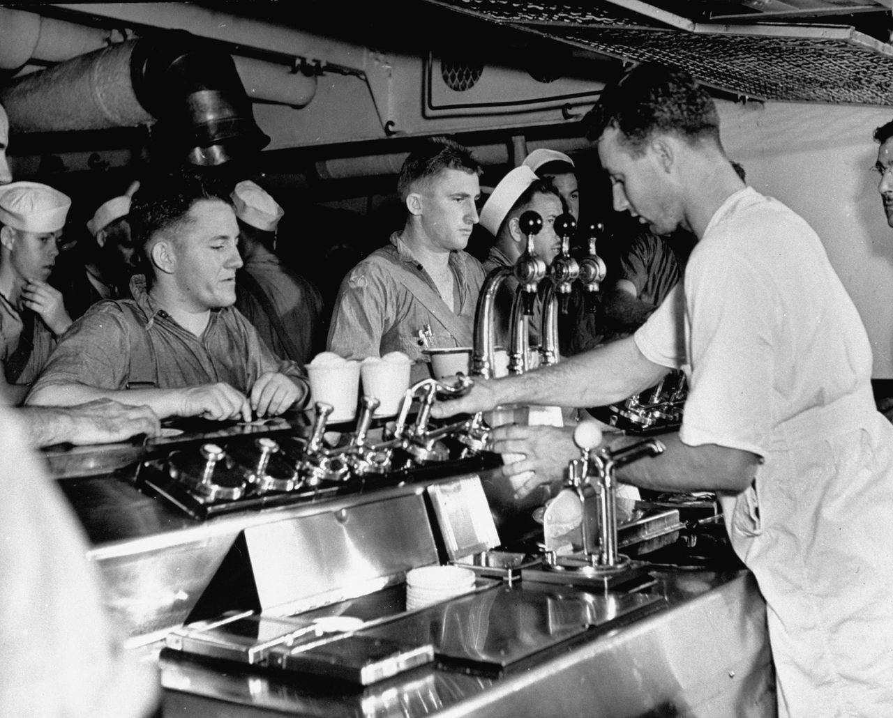 During WWII, sailors aboard a US Navy cruiser at sea flocked to the ice cream fountain.