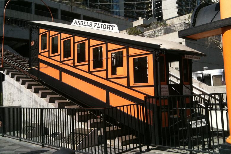 An orange and black funicular car labeled Angels Flight sits on a steep track in downtown Los Angeles.