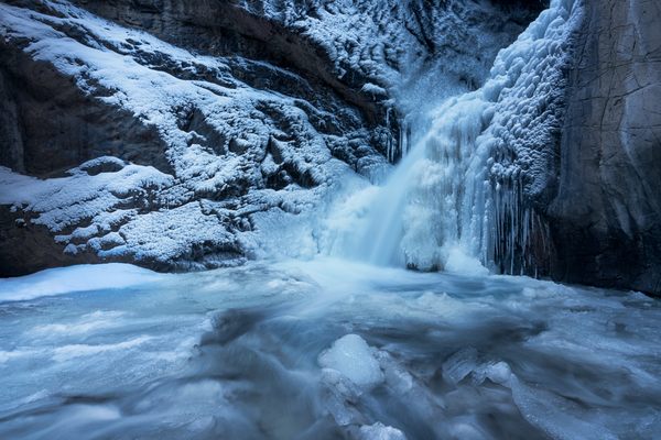 Thousands of gallons of water spill down this 285-foot waterfall, which terminates in a frozen wonderland.