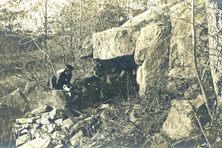 A woman peering into the cave of Sarah Bishop c. 1900.