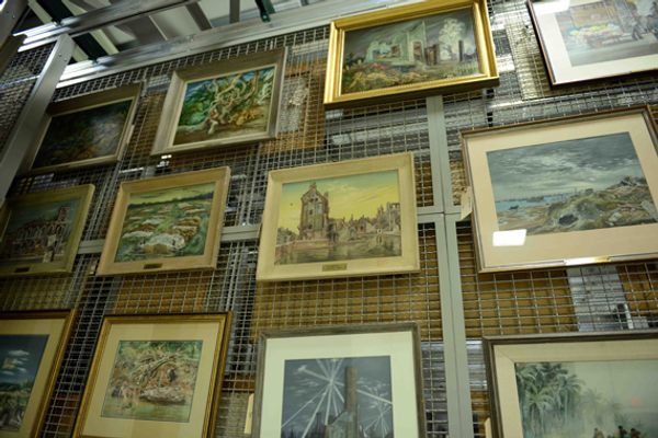 The paintings are stored on tightly packed vertical wire partitions to save space.